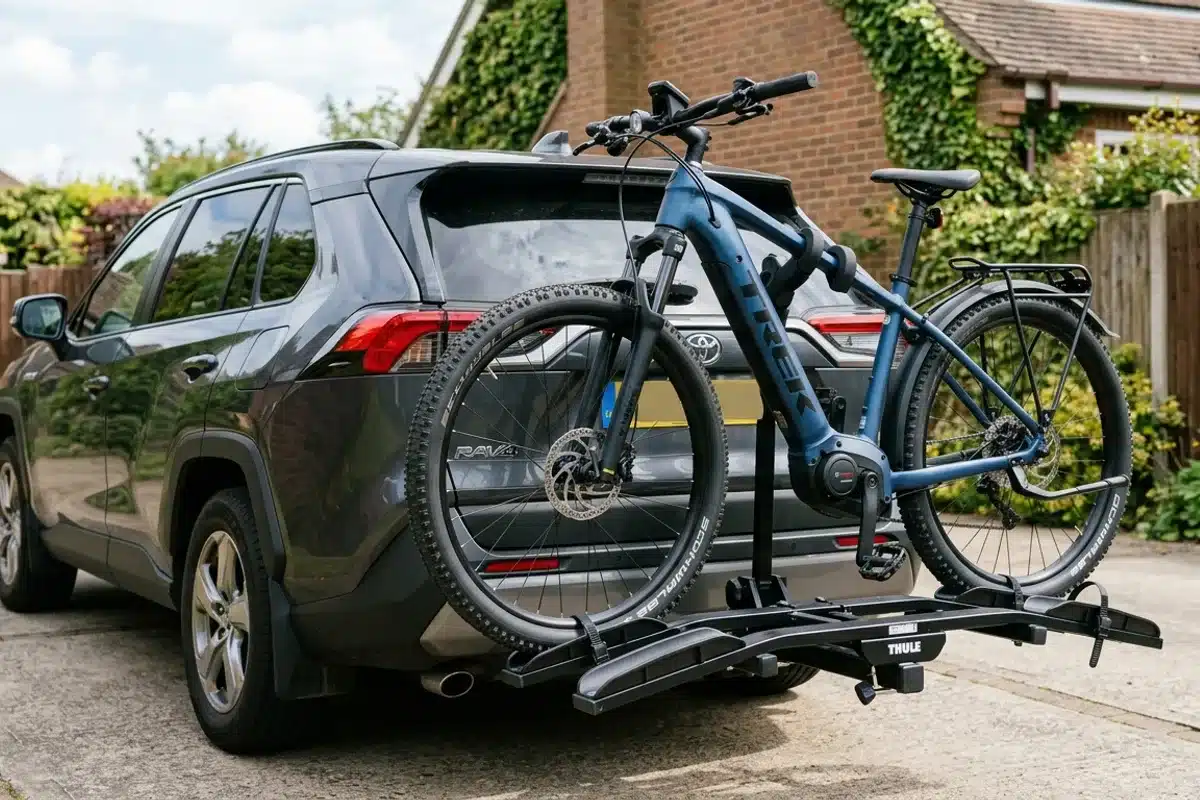 Vélo électrique fixé sur un porte-vélo d'attelage à l'arrière d'un SUV Vélo électrique transporté sur un porte-vélo d'attelage monté sur un SUV