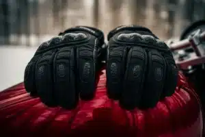 Gants moto hiver noirs posés sur le réservoir d une moto, décor hivernal
