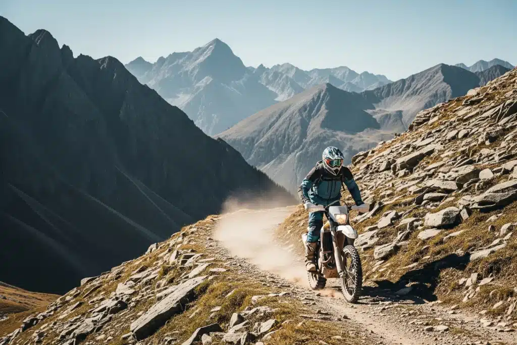 Rider sur moto trail tout-terrain traversant un chemin rocheux en montagne