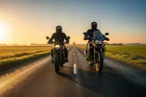 Deux motards sur une route de campagne au lever du soleil, symbolisant la diversite des types de moto