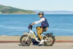 Cycliste sur un vélo électrique 45 km/h de type speed bike sur une route côtière