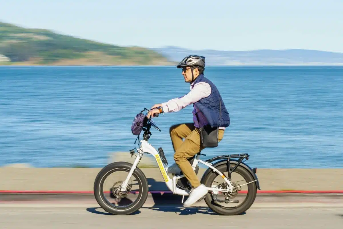 Cycliste sur un vélo électrique 45 km/h de type speed bike sur une route côtière