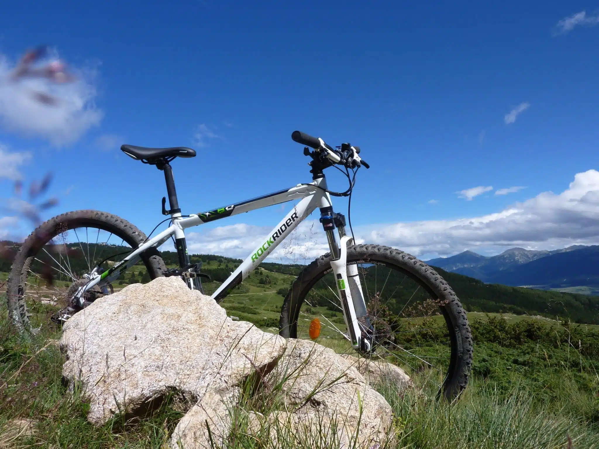 VTT avec fourche télescopique à l'avant, posé contre un rocher en montagne